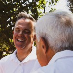 Pflegekraft und älterer Herr lachen gemeinsam